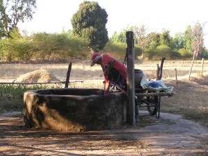 村の外れの井戸から水を汲み上げる村人