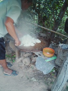 蒸しあがったカオニアオを木の棒で混ぜながら蒸らす